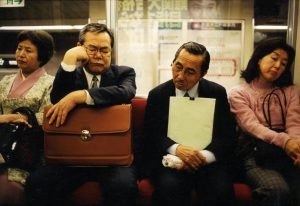 Japanese businessmen take a nap on a metro in Tokyo.