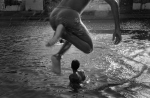 Children jump into a pond in Mumbai, India