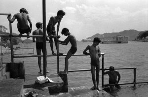 Young Indians perch on the bars to bathe in a lake in Udaipur, India.
