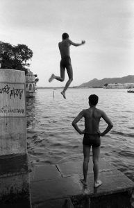 Indian boys jump into the river in Mumbai.
