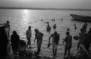 Indian people bathes in the Ganges river in the evening.