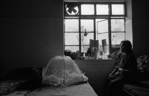 An exiled Tibetan mother with her baby on the bed in a refugee center in Dharamsala, India.