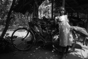 A Tanzaian girl in front of a bicycle in Zanzibar, Tanzania.