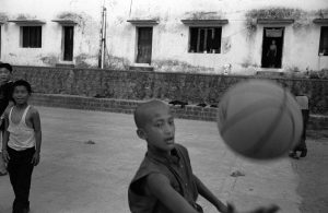 Tibetan monks play basketball beside the Tibetan monastery in Bir, India